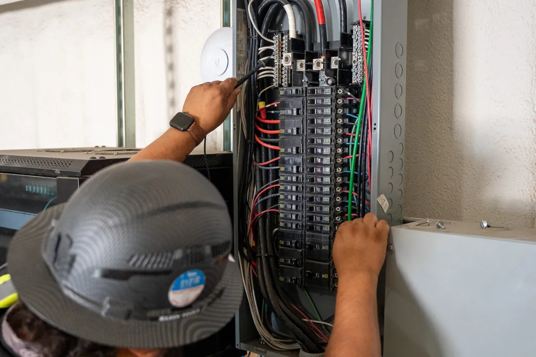 Electrician working inside a commercial panel