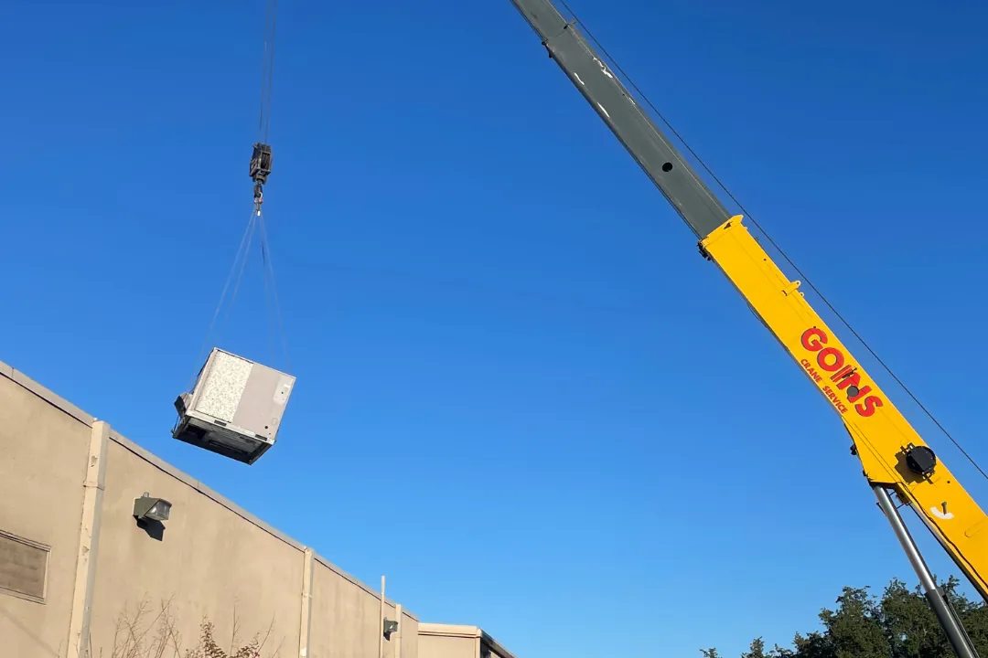 Crane lifting equipment to a commercial roof